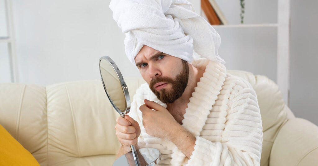 a man inspects a cyst on his face and wonders what it could be