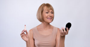 A woman admires the results of her Kybella treatment